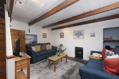 a living room with two blue couches and a fireplace at Cosy Cottage in St Ives, Wi-Fi, Pets Accepted in St Ives