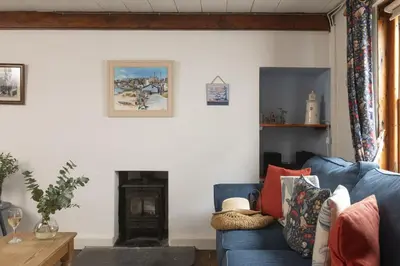 a living room with a blue couch and a fireplace at Cosy Cottage in St Ives, Wi-Fi, Pets Accepted in St Ives