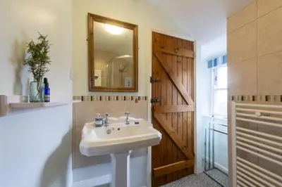 a bathroom with a sink and a mirror at Cosy Cottage in St Ives, Wi-Fi, Pets Accepted in St Ives