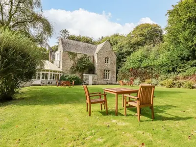 a table and chairs in front of a house at Villa 18 Lanteglos Holiday Park in Camelford