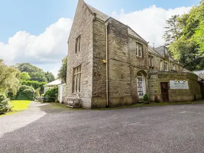 an old brick building with a driveway in front of it at Villa 18 Lanteglos Holiday Park in Camelford