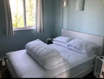 a bed with white sheets and pillows in a bedroom at Tolroy Manor - 84 Strawberry Hill in Hayle