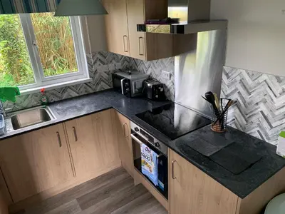 a kitchen with a sink and a stove top oven at Tolroy Manor - 84 Strawberry Hill in Hayle