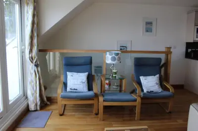 two chairs and a table in a living room at Apartment 19 in Downderry