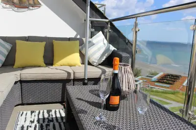 a bottle of wine and two glasses on a table at Apartment 19 in Downderry