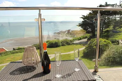 a bottle of wine sitting on a table with two glasses at Apartment 19 in Downderry