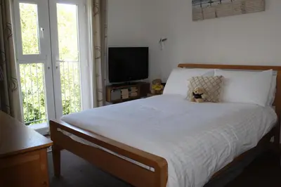 a bedroom with a bed with a teddy bear on it at Apartment 19 in Downderry