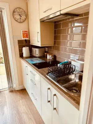 a kitchen with a sink and a clock on the wall at Cosy Couples Getaway - The Nook, set in 6 acres of private grounds in Truro