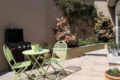 a patio with a table and chairs and a stove at Cosy Couples Getaway - The Nook, set in 6 acres of private grounds in Truro