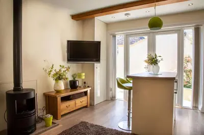 a living room with a television and a stove at Cosy Couples Getaway - The Nook, set in 6 acres of private grounds in Truro