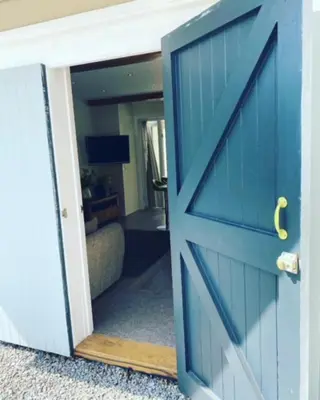 a blue door leading into a living room at Cosy Couples Getaway - The Nook, set in 6 acres of private grounds in Truro