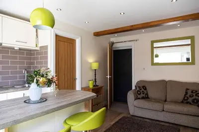 a kitchen and living room with a couch and a table at Cosy Couples Getaway - The Nook, set in 6 acres of private grounds in Truro