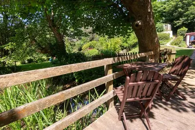 two chairs and a table on a wooden deck at Spacious Farmhouse between St Agnes & Porthowan in Truro