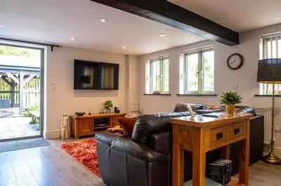 a living room with a leather couch and a table at Little Willow in Saint Columb Major