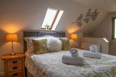 a bedroom with a bed with two stuffed animals on it at Little Willow in Saint Columb Major