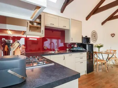 a kitchen with white cabinets and a stove top oven at The Stables in Saint Columb Major