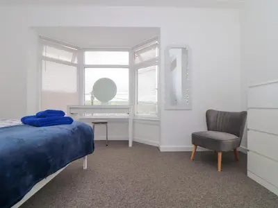 a bedroom with a bed and a desk and a chair at Small Hillman in Perranporth