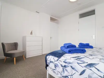 a bedroom with a bed and a chair at Small Hillman in Perranporth