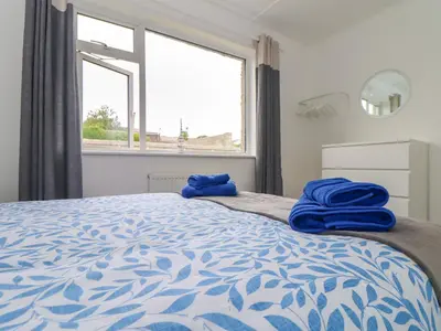 a bedroom with a bed with blue towels on it at Small Hillman in Perranporth