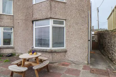 a table and two chairs in front of a building at Small Hillman in Perranporth
