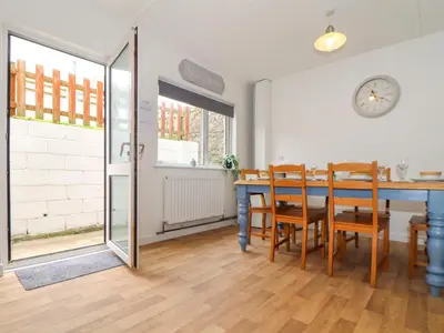 a dining room with a blue table and chairs at Small Hillman in Perranporth
