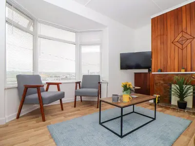 a living room with two chairs and a table at Small Hillman in Perranporth