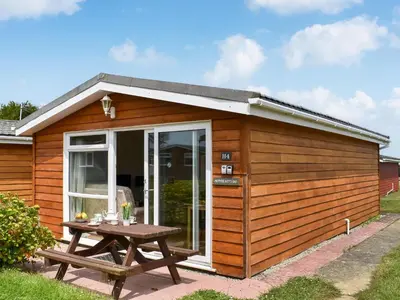 a wooden shed with a picnic table in front of it at Mother Ivy's Bay - Uk47553 in St Merryn