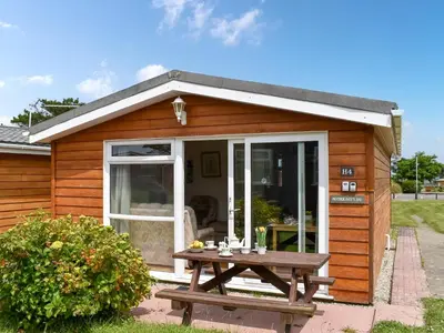 a wooden shed with a picnic table in front of it at Mother Ivy's Bay - Uk47553 in St Merryn