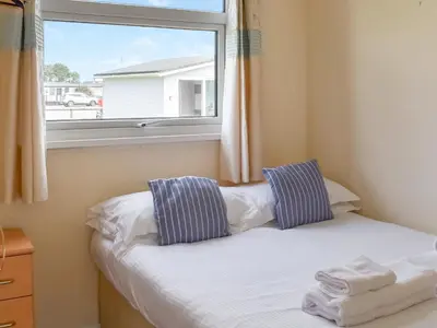 a small bedroom with a window and a bed at Mother Ivy's Bay - Uk47553 in St Merryn