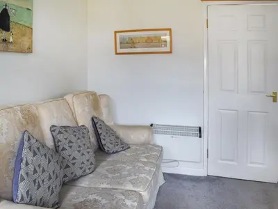 a couch with pillows on it in a living room at Trevose Head - Uk47556 in St Merryn