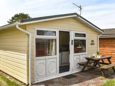 a small shed with a door and a table at Trevose Head - Uk47556 in St Merryn