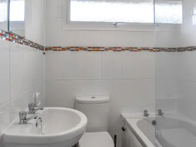 a white bathroom with a toilet and a tub and a sink at Trevose Head - Uk47556 in St Merryn