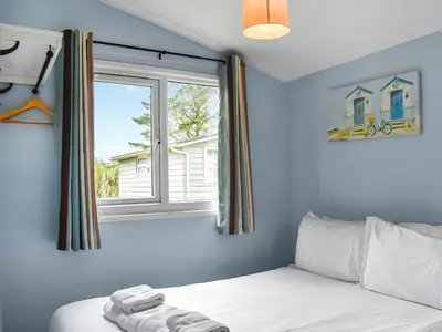 a bedroom with a bed and a window at Trevose Head - Uk47556 in St Merryn