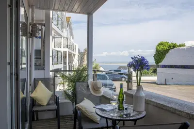 a balcony with a table and a view of the ocean at Apartment By The Sea, Wi-Fi, Pets Accepted in St Ives