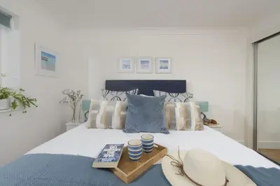 a bedroom with a bed with hats and a tray on it at Apartment By The Sea, Wi-Fi, Pets Accepted in St Ives