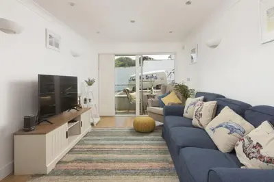 a living room with a blue couch and a tv at Apartment By The Sea, Wi-Fi, Pets Accepted in St Ives