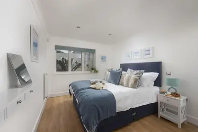 a white bedroom with a large bed and a window at Apartment By The Sea, Wi-Fi, Pets Accepted in St Ives