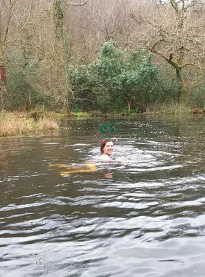 a woman is swimming in a body of water at Meadow Bluebird in Bodmin