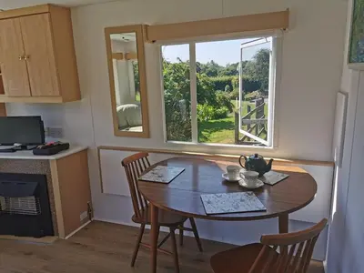 a table and chairs in a kitchen with a window at Meadow Bluebird in Bodmin