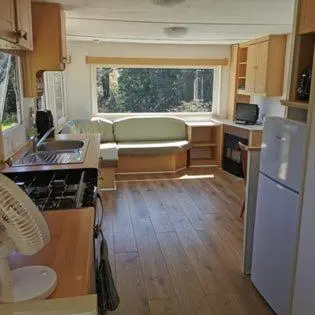 a small kitchen with a couch and a refrigerator at Meadow Bluebird in Bodmin