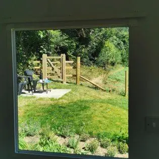 a window view of a yard with a fence at Meadow Bluebird in Bodmin