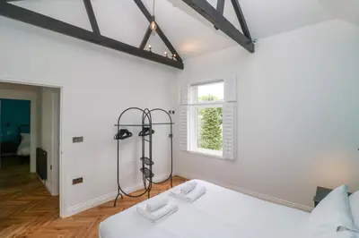 a white bedroom with a bed and a window at St Piran in St Ives