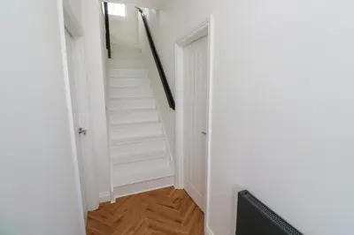 a hallway with white stairs and a stair case at St Piran in St Ives