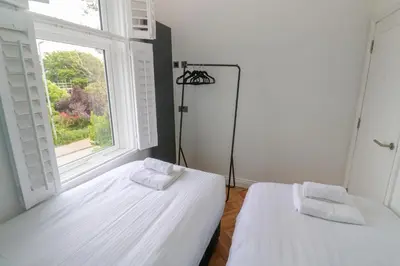 two beds in a room with a window at St Piran in St Ives