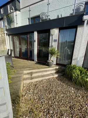 a house with a wooden deck and a building at No1 Apartment Mevagissey in Mevagissey