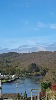 a view of a river with mountains in the background at Driftwood in Looe River view and parking in Looe