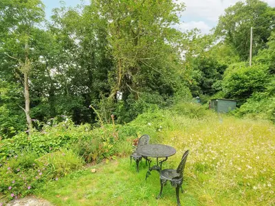 two chairs and a table in a field at Jordan Cottage in Fowey