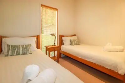 a bedroom with two beds and a window at 10 Water's Edge in Looe