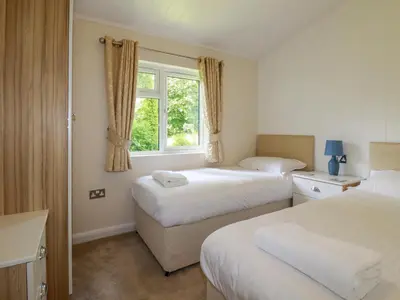 a hotel room with two beds and a window at 43 The Maples in St Austell