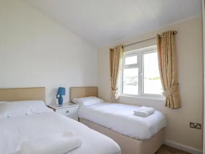 two beds in a room with a window at 43 The Maples in St Austell